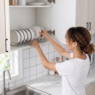 Femme qui place un bol dans l'organisateur cuisine