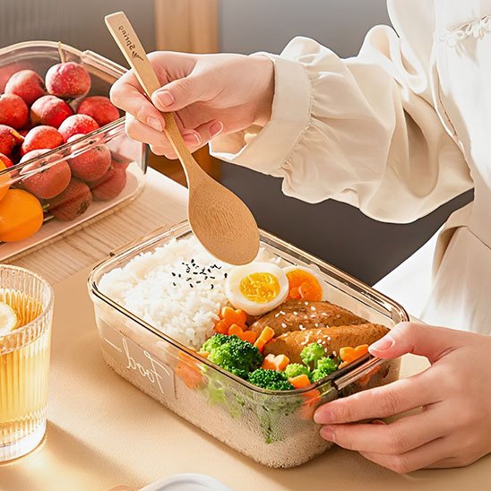 Femme qui prépare un repas dans la boite de conservation alimentaire 