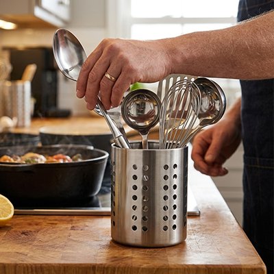 Homme prend une louche dans le Pot ustensiles Cuisine