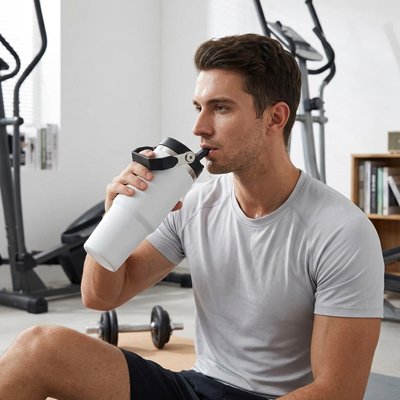 Homme qui boit dans son Mug isotherme blanc