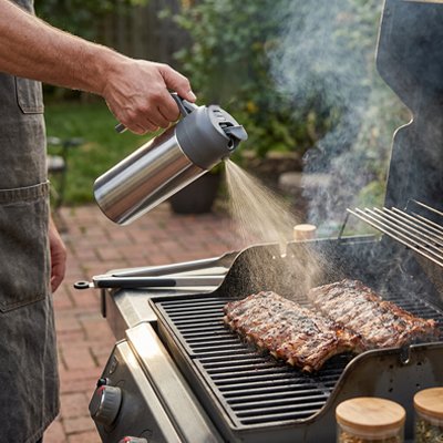 homme qui utilise le Vaporisateur huile sur la cuisson au BBQ