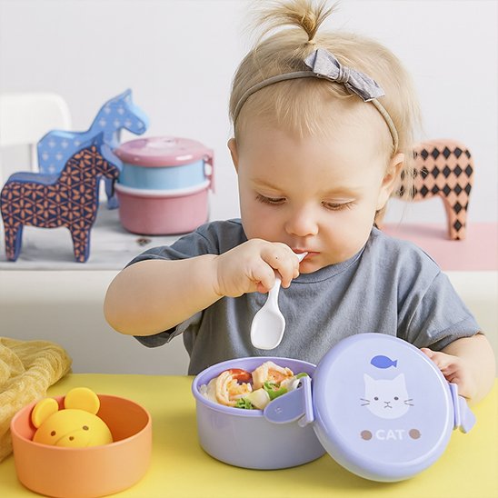 Petite fille qui mange dans son lunch box enfant bleu