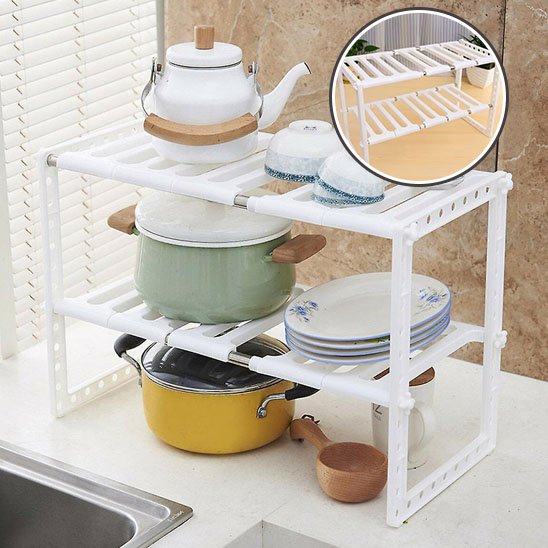 Rangement sous evier blanc avec poèlons assiettes bols et théière