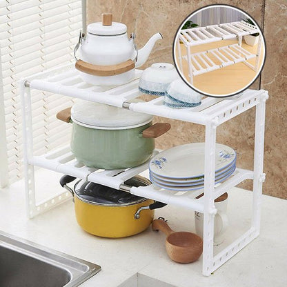 Rangement sous evier blanc avec poèlons assiettes bols et théière