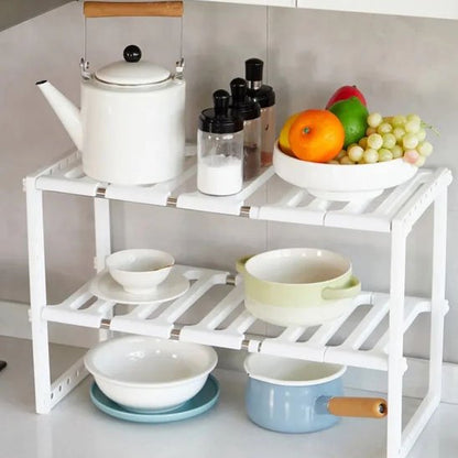 Rangement sous evier blanc sur le comptoir de cuisine avec corbeille à fruits dessus