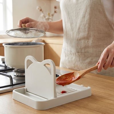 Repose cuillère blanche avec une dame qui fait le repas